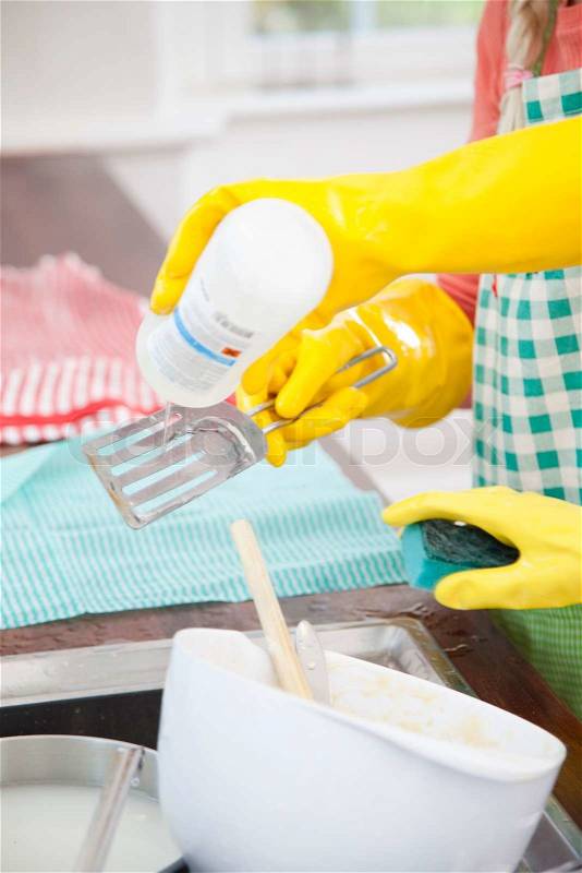Girls cleaning dirty kitchen wares, stock photo