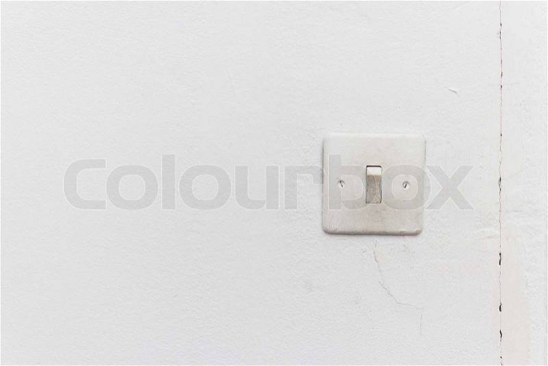 Old light switch on the white wall, stock photo