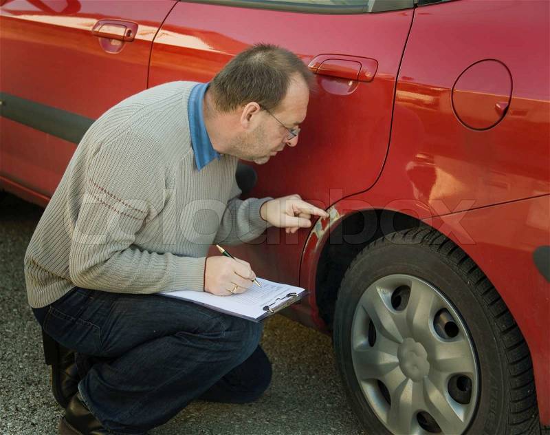 Expert insurance at an auto body damage, stock photo