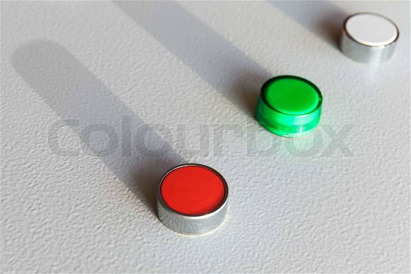 Three industrial buttons on gray steel control panel, stock photo