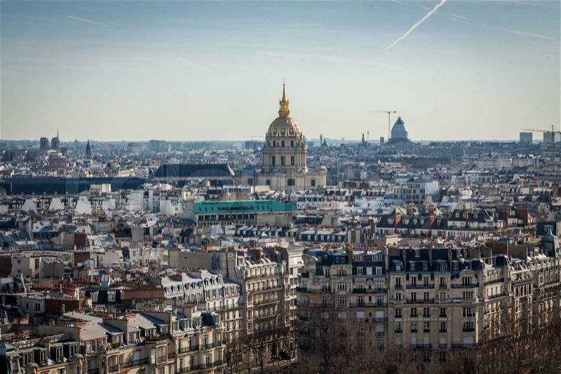View over the rooftops of Paris, France with its streets of historical buildings to a distant skyline under a blue sky, travel concept, stock photo