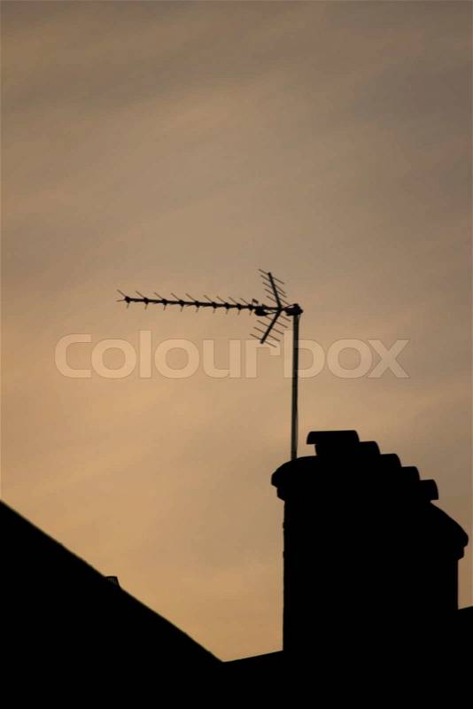 TV arial television antenna and chimney on roof of an urban high rise building and attractive blue purple dusk sunset sky in London England. , stock photo