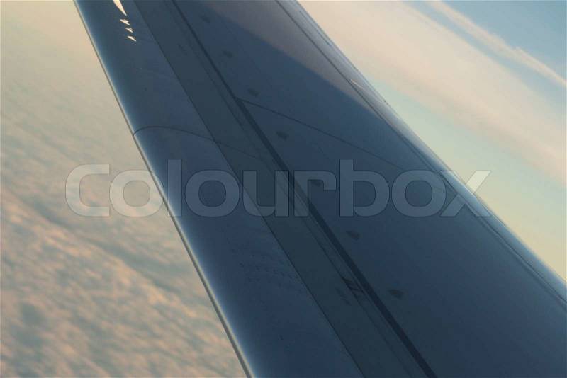 Airplane flying in sky in flight metal wing, stock photo