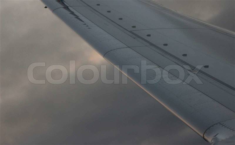 Airplane flying in sky in flight metal wing, stock photo