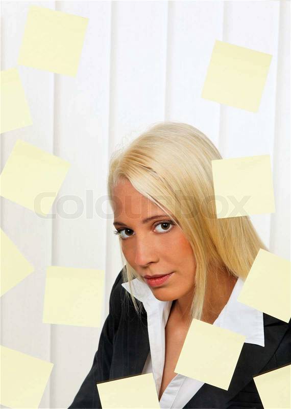 Stressed-out young woman with multiple assignments memos, stock photo