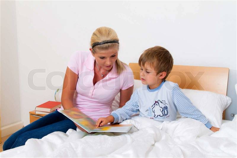 A mother and child in bed to read the stories, stock photo