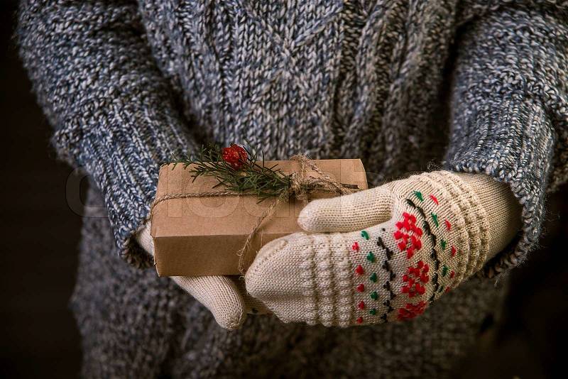 Woman with a Christmas gift in hands, studio, stock photo