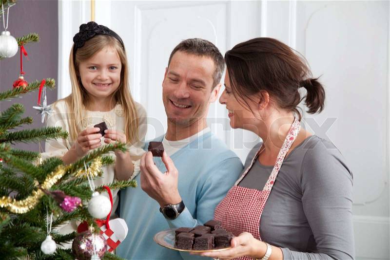A happy family eating chocolate on Christmas day, stock photo