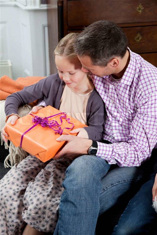 A dad giving gift to his daughter on Christmas day, stock photo