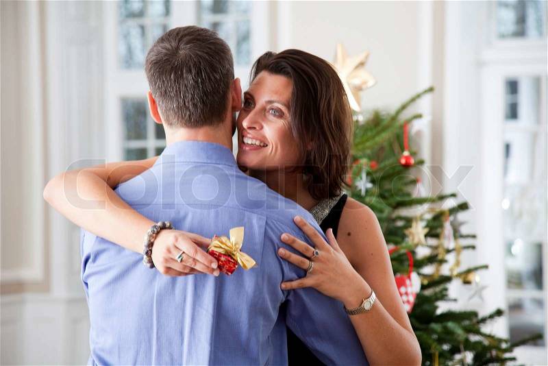 A very happy wife receiving her Christmas present from her husband, stock photo