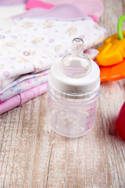 Clothing and accessories for babies, toy beanbag and bottle of feeding, stock photo