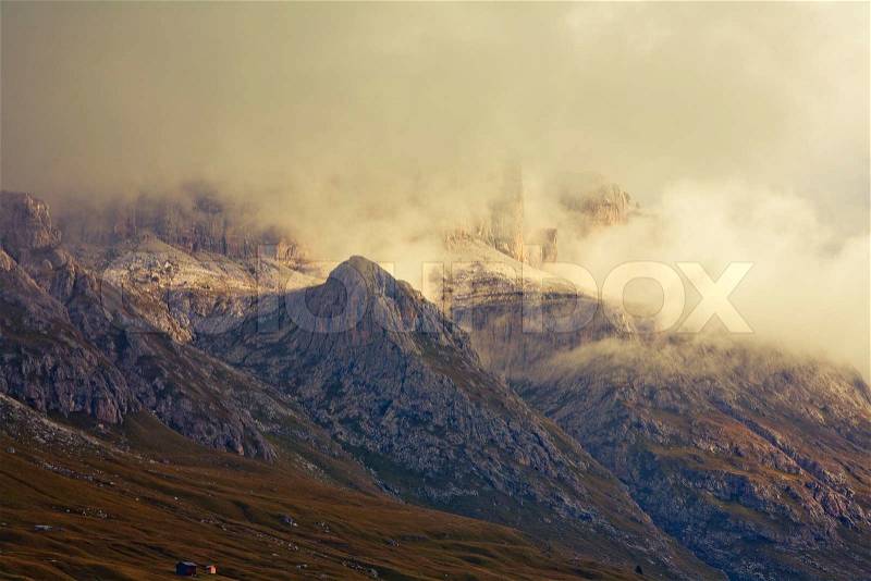 September morning with low hanging clouds in the Dolomites. Image is cross processed and a little film grain added to reflect age, stock photo