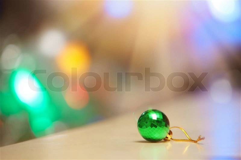 Green Christmas ball and illuminated background, stock photo
