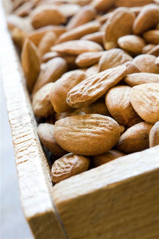 Macro shot of shelled almonds displayed in wodden box, stock photo
