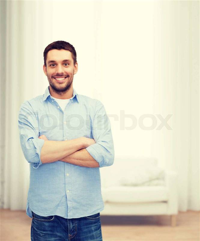 Happiness and people concept - smiling man with crossed arms, stock photo