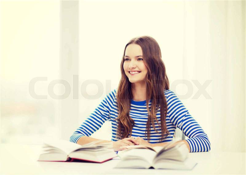 Education and home concept - happy smiling student girl with books, stock photo