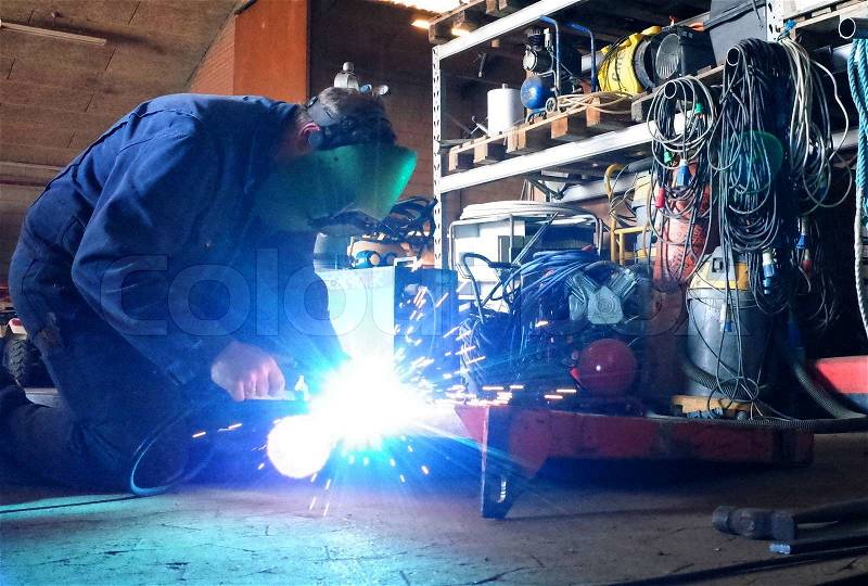 Welder in work with welding in the workshop , stock photo