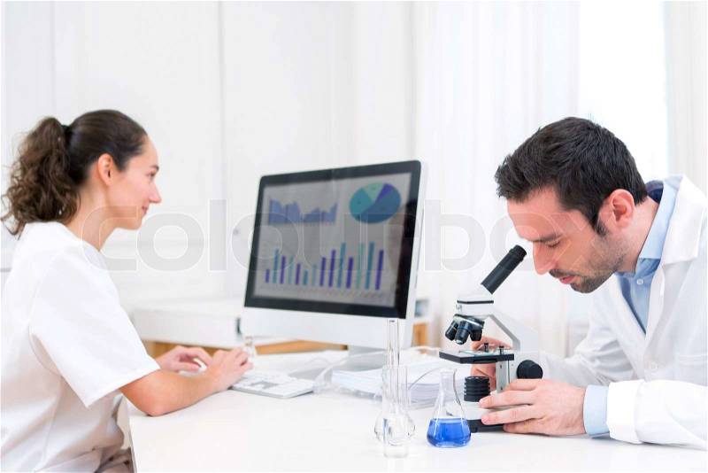 View of a Scientist and her assistant in a laboratory, stock photo