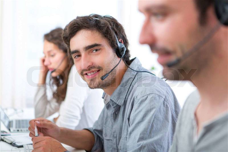 View of a Young attractive man working in a call center, stock photo