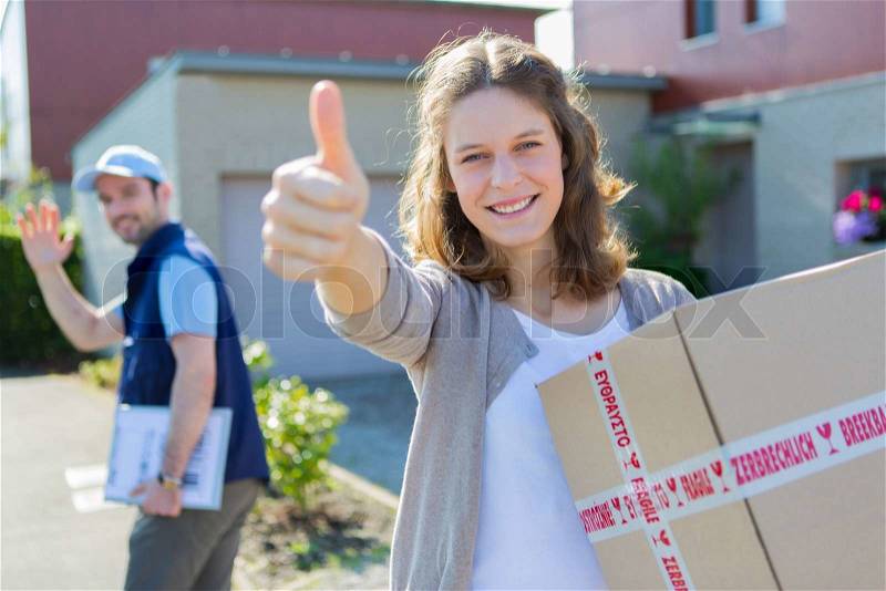 View of a Young attractive woman happy to receive parcel, stock photo