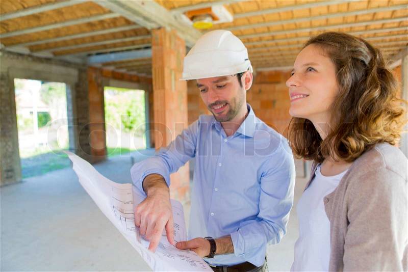 View of a Young woman and architect on construction site , stock photo