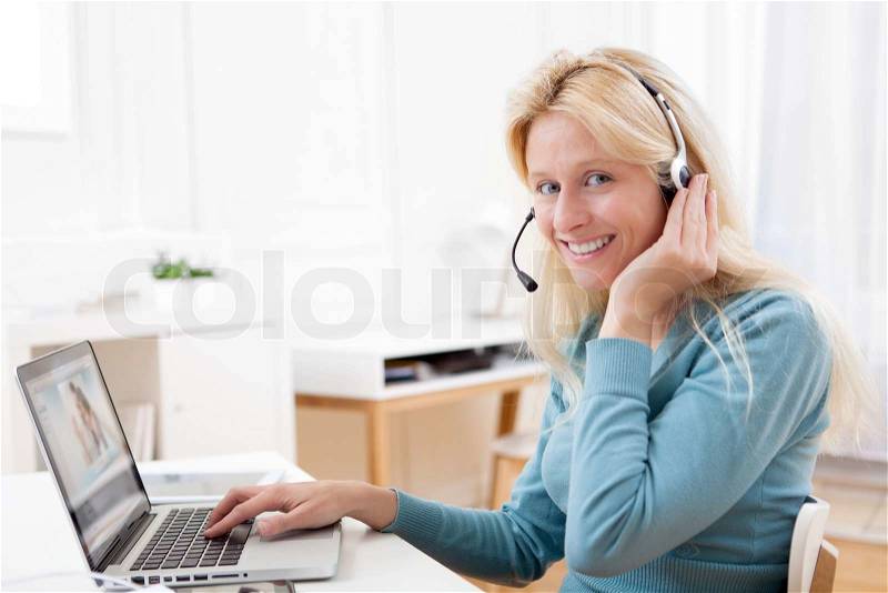 View of Young attractive woman blonde chatting on laptop, stock photo