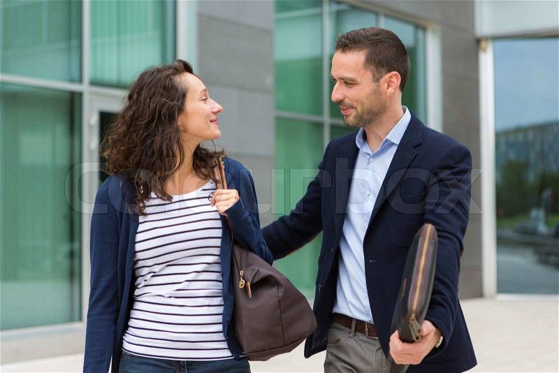 VIew of a business man and woman chatting together after work, stock photo