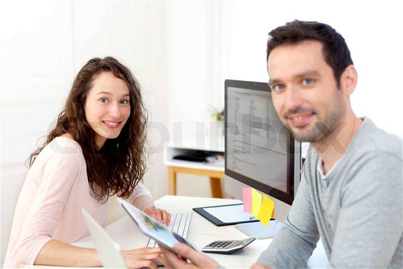View of Young attractive co-workers at the office, stock photo