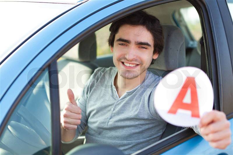 View of a young man happy to get his driving license, stock photo