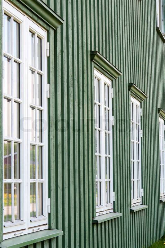 White wooden windows and green walls - traditional architecture in Norway, stock photo
