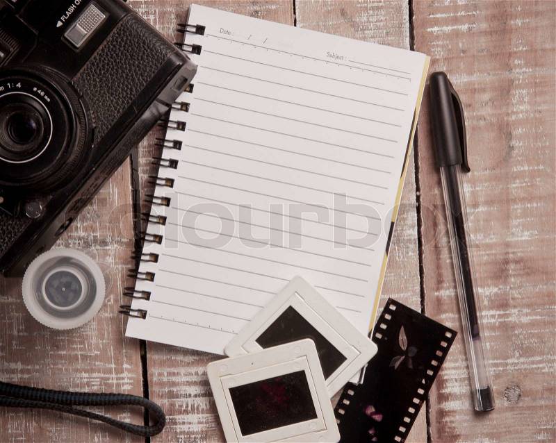 Old camera and film with diary on a wooden,vintage color toned image, stock photo