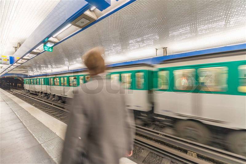 Blurred picture of moving business man in Paris Metro with train speeding up, stock photo