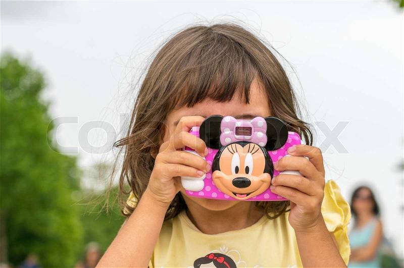 PARIS, FRANCE - JULY 20, 2014: Baby girl enjoy city view with her toy camera. More than 30 million tourists visit Paris every year, stock photo