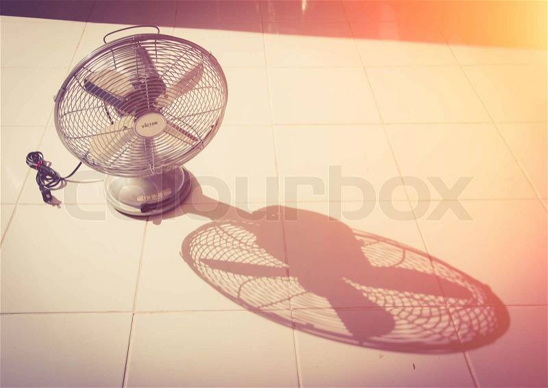 Vintage Antique fan and shadow on tiled floor, stock photo