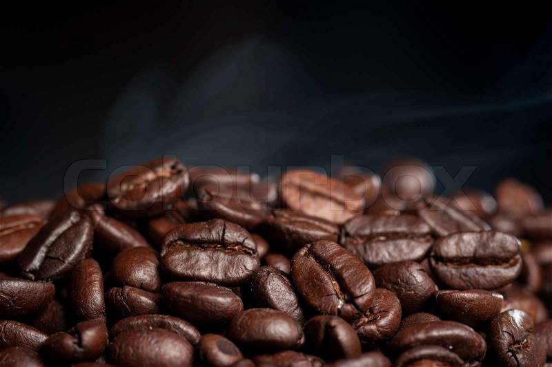Coffee beans roasting with smoke, stock photo