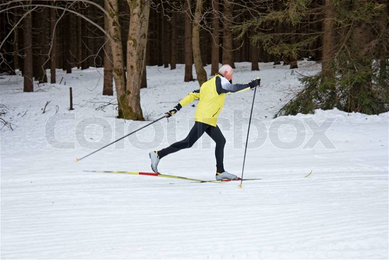 Senior at the snow in winter on cross country skis, stock photo