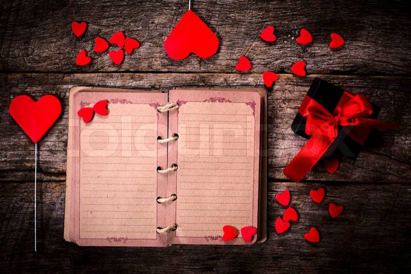 Old blank small book with the hearts on wooden background , stock photo