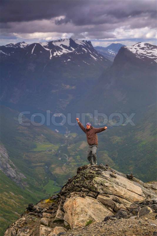 Happy man on the top of a high mountain, stock photo