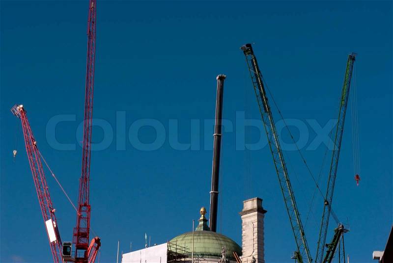Construction cranes outdoors sky blue and high up in London, England, stock photo