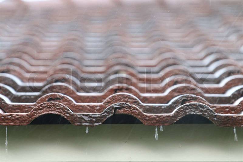 Falling Rain drop on brown brick roof, close up. , stock photo