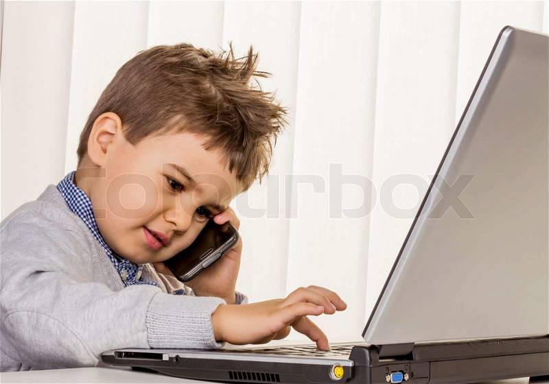 Little boy on a laptop, symbol of the internet, e-commerce, consumer behavior, surfing, stock photo