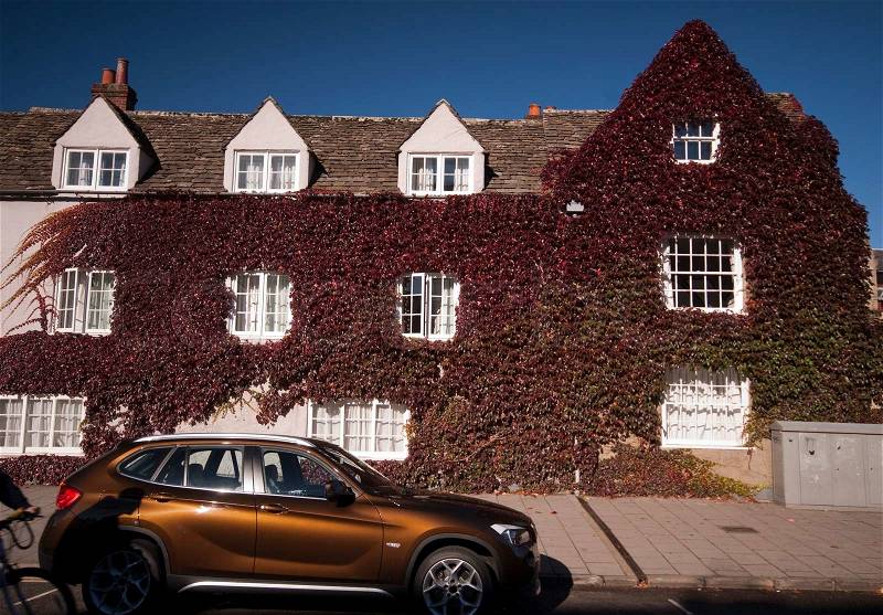 Bicycle shadow, shiny car and autumn creeper house in Oxford, Oxfordshire, England, stock photo