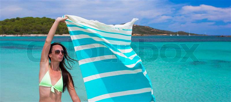 Little girl running along the beach with towel and very happy, stock photo