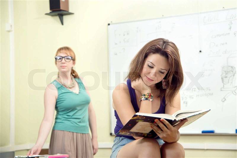 Cheerful teacher with students posing in front of blackboard, stock photo