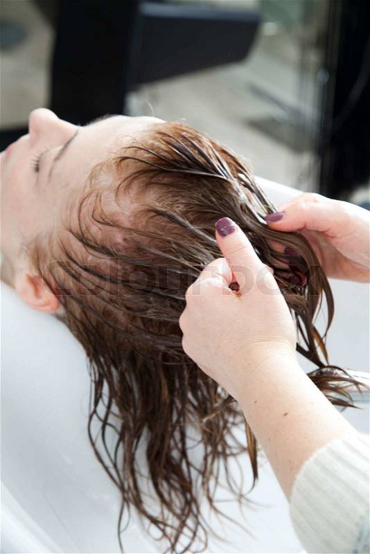 A woman getting her hair washed in a hair salon, stock photo