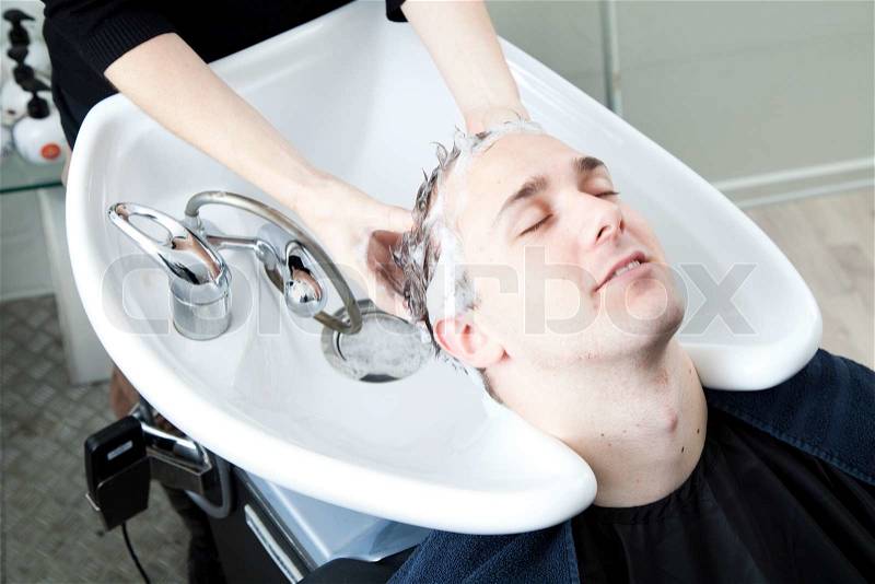 A caucasian man getting his hair washed in hair salon, stock photo