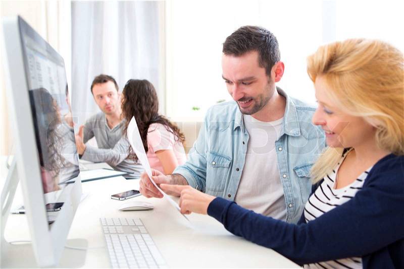 View of a Young attractive people working together at the office , stock photo