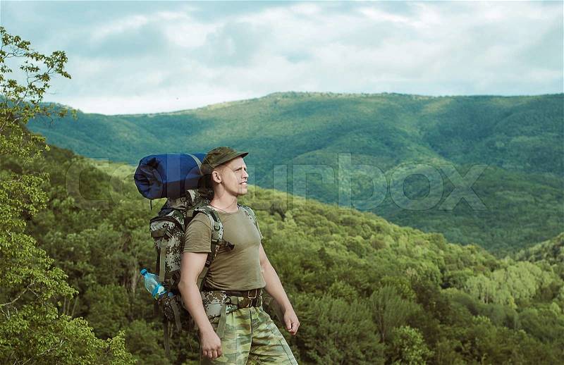 Young man hiking smiling happy portrait. Male hiker walking in forest, stock photo