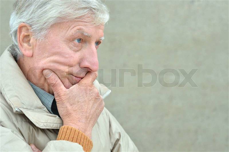 Portrait of cold senior man on grey background, stock photo