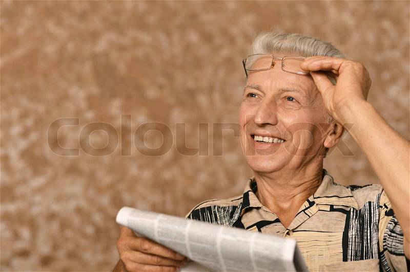 Senior man reading newspaper, stock photo